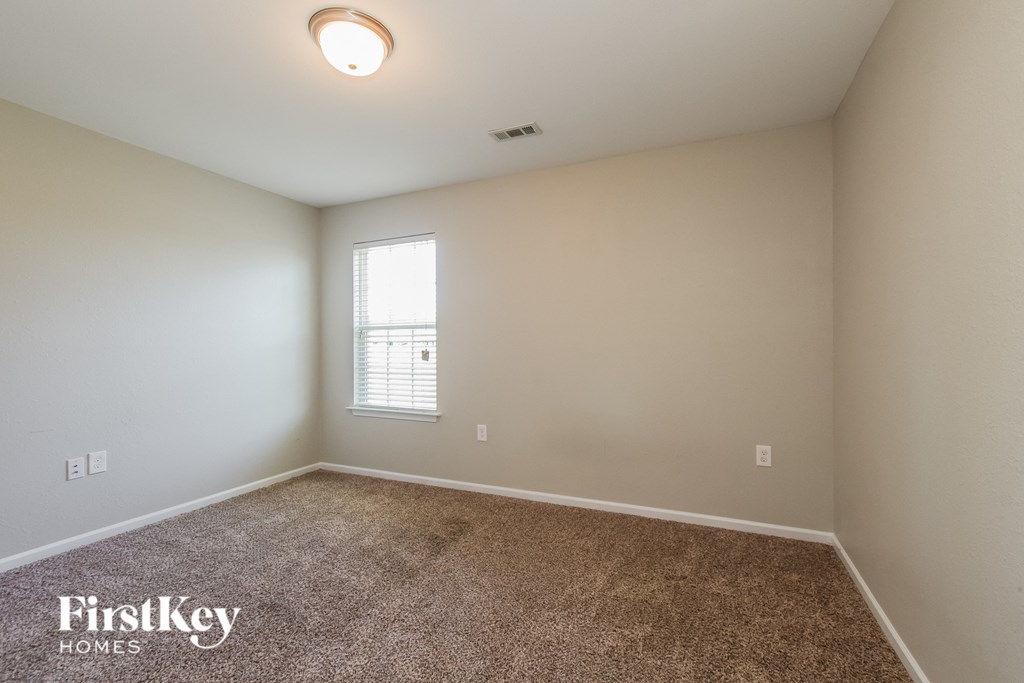 a bedroom with a carpeted floor and a window