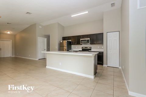 A kitchen with a white countertop and a stove top oven.