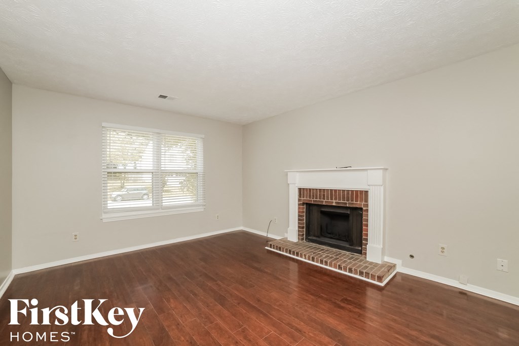 a living room with wood floors and a fireplace