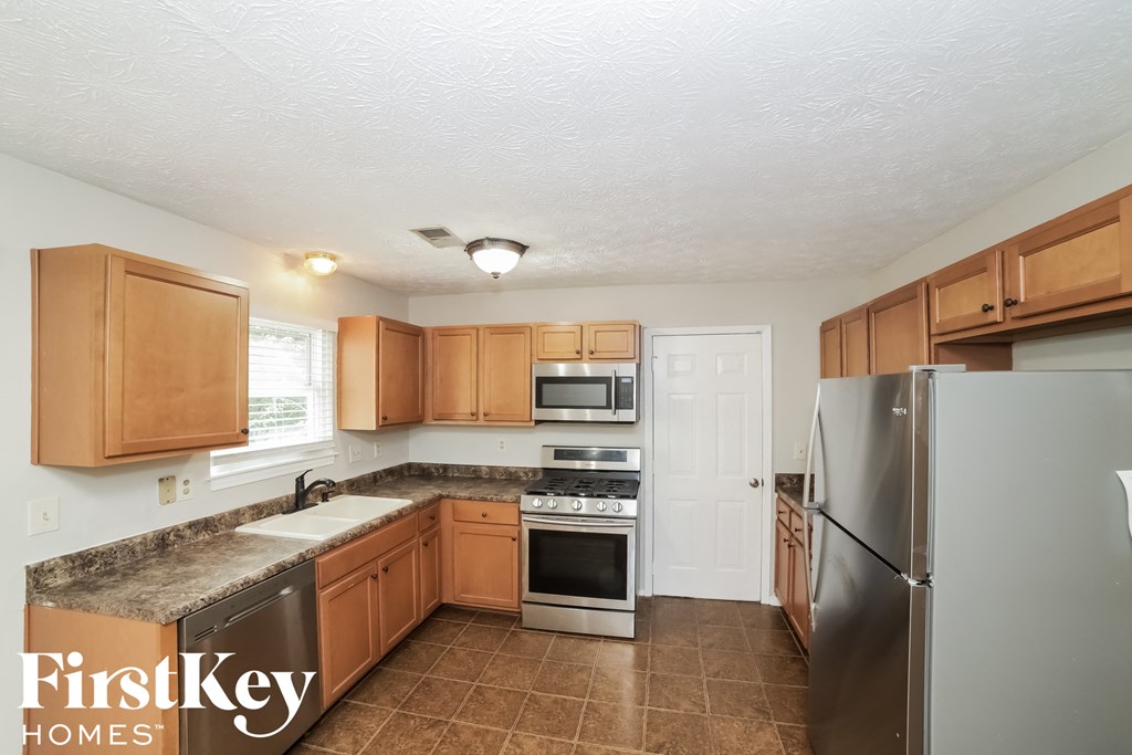 a kitchen with wooden cabinets and stainless steel appliances