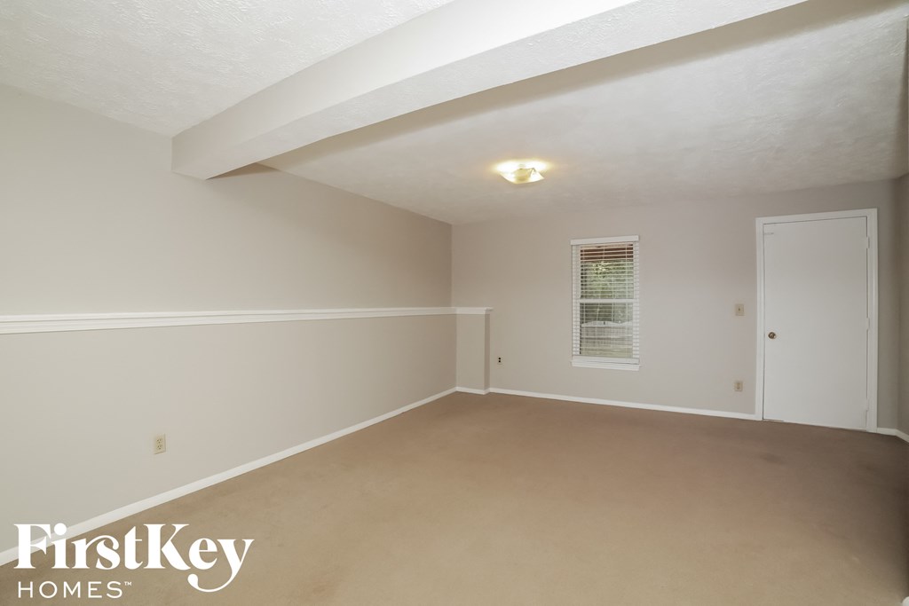 a bedroom with white walls and white carpet and a white door