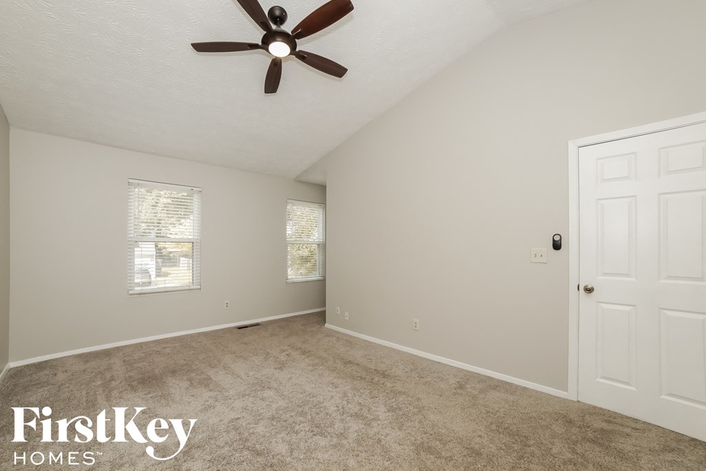 a bedroom with a ceiling fan and a white door