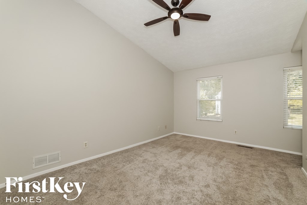 a bedroom with a carpeted floor and a ceiling fan