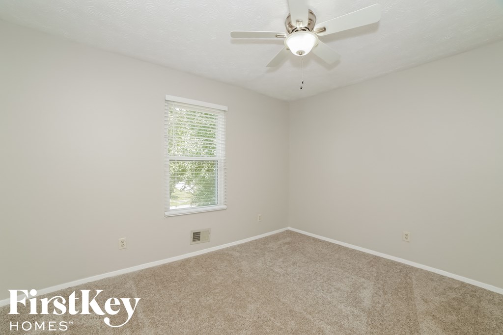 a bedroom with carpet and a ceiling fan