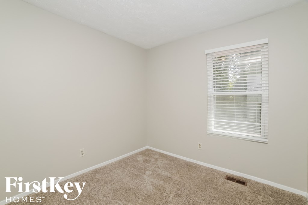 a bedroom with a carpeted floor and a window