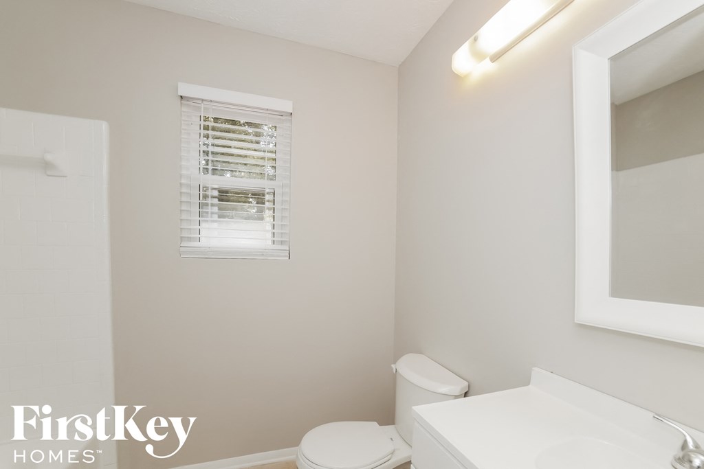 a bathroom with a toilet and a sink and a mirror