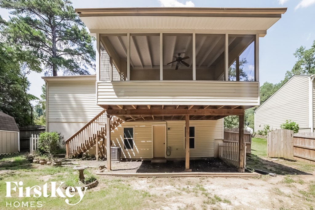 the front of a house with a porch with a fan on it