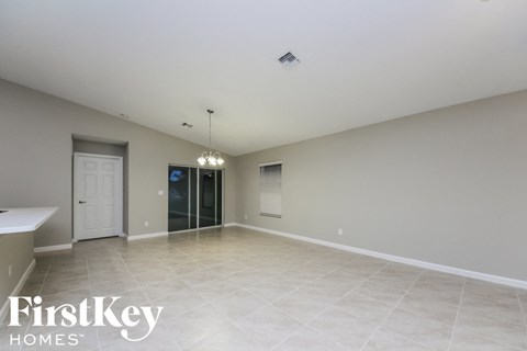 A spacious empty room with a door and a window.