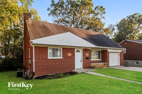 a small brick house with a white door and a lawn