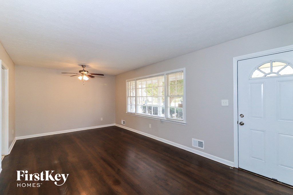the living room of an empty house with wood floors and a ceiling fan