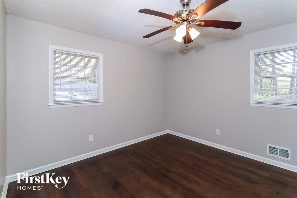 the bedroom with hardwood flooring and a ceiling fan