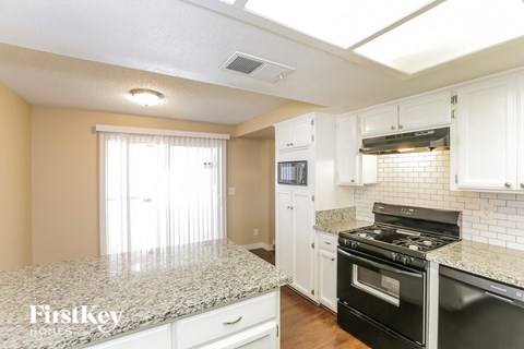 A kitchen with granite countertops and white cabinets.