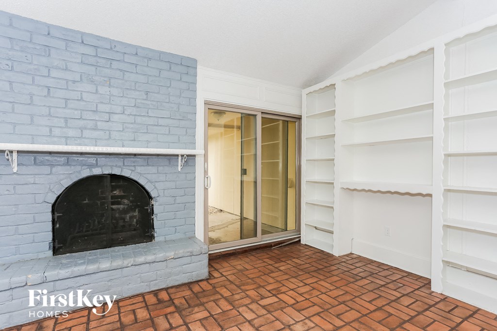 a blue brick fireplace in a living room with white shelves