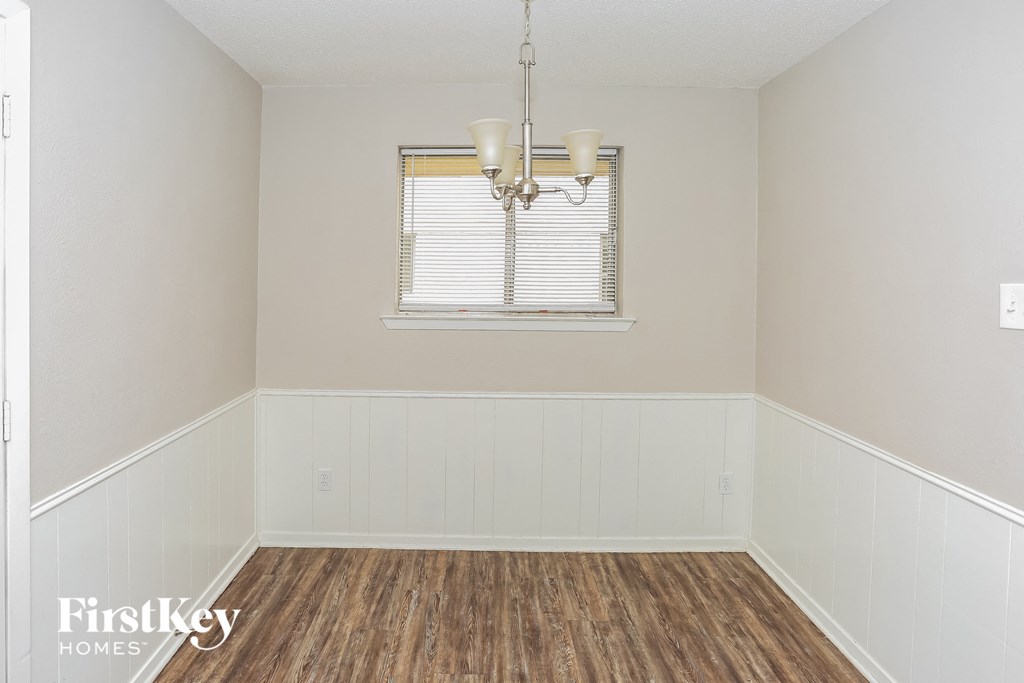 an empty room with wood floors and a window