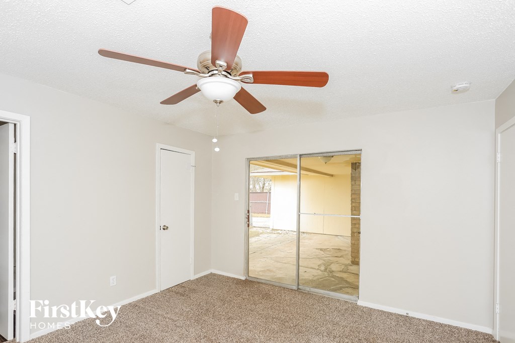 a bedroom with a ceiling fan and a mirrored closet