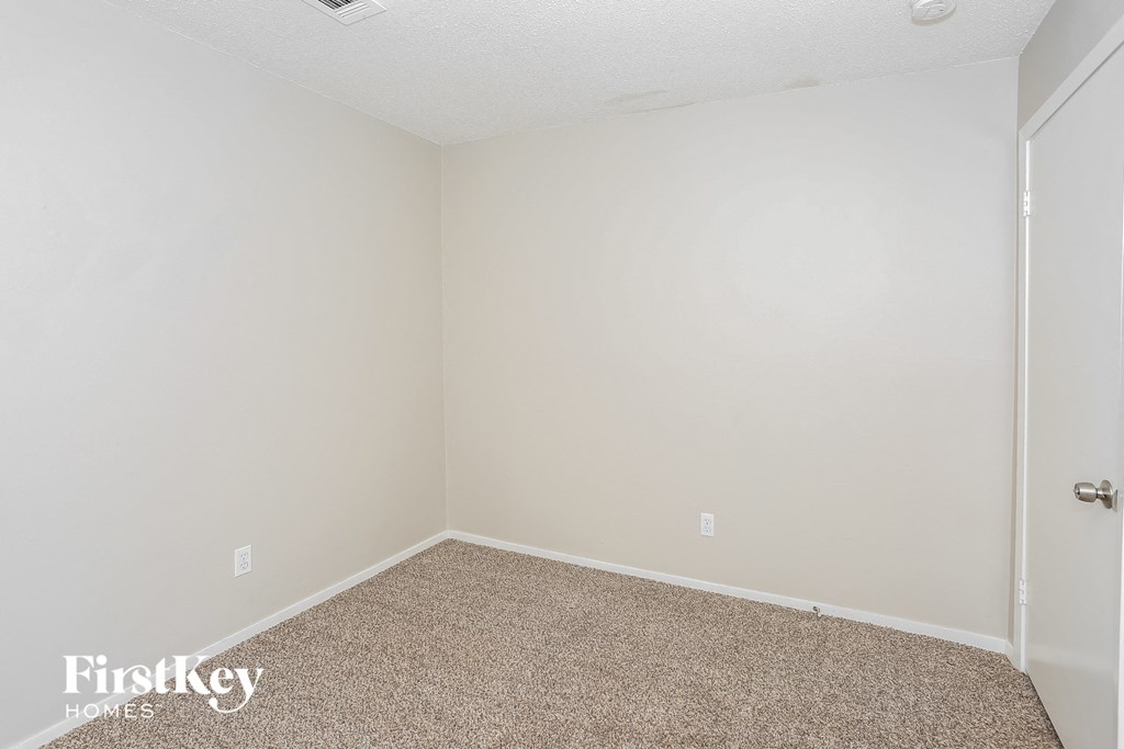 a empty room with a carpeted floor and a white wall