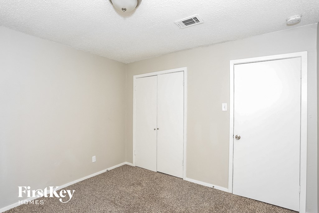 a bedroom with two closets and a carpeted floor