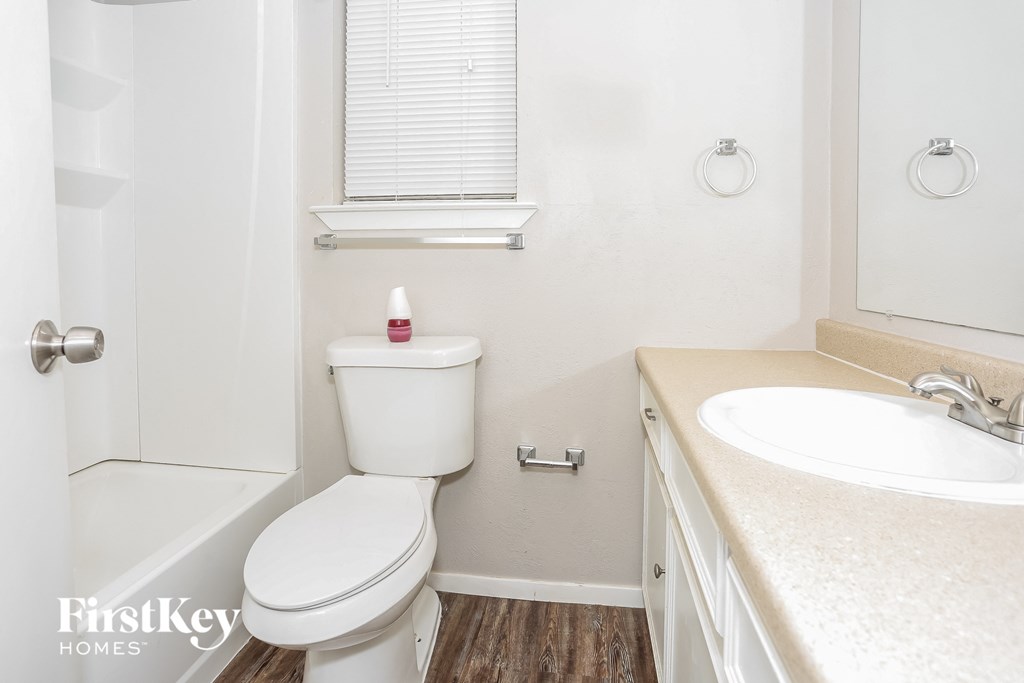 a bathroom with a toilet and a sink and a bath tub