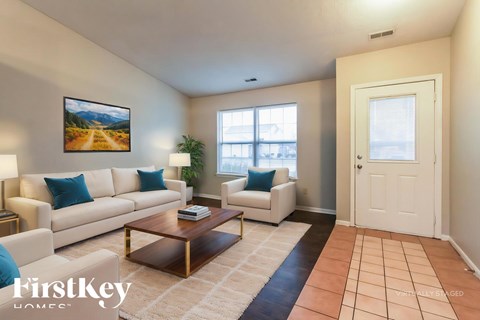 A living room with a white couch, a coffee table, and a painting on the wall.