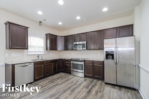 A kitchen with dark brown cabinets and stainless steel appliances.