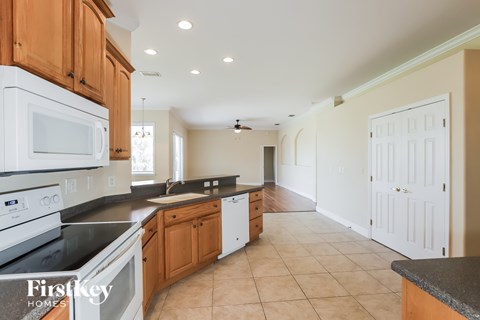 A kitchen with a black counter top and wooden cabinets.