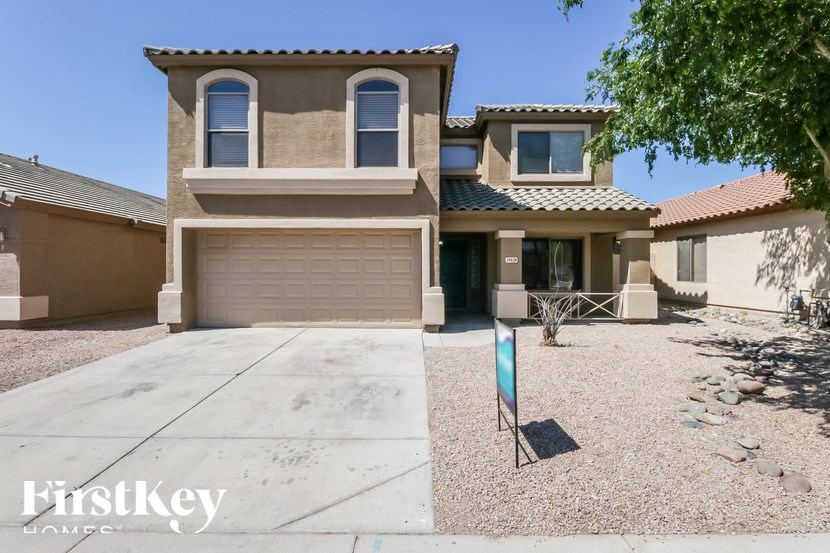 A house with a garage and a driveway in front of it.