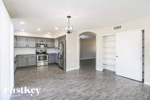 A kitchen with a refrigerator, oven, and microwave.