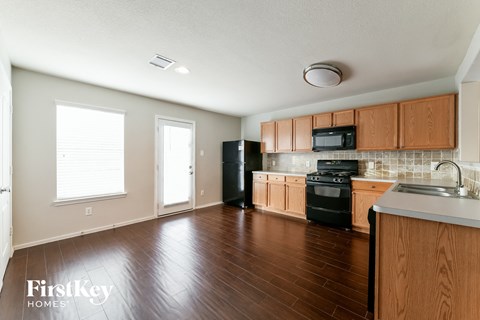 A kitchen with wooden cabinets and black appliances.