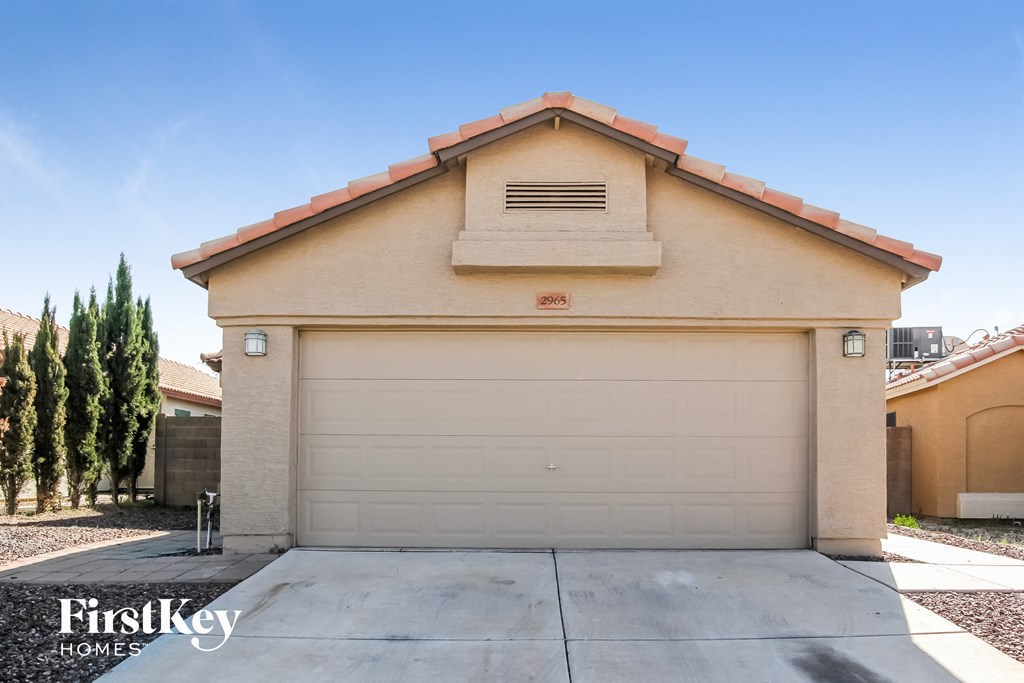 a white garage door on a house with a driveway