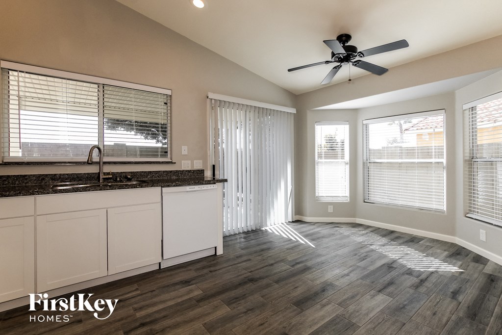 a kitchen and living room with a ceiling fan and windows