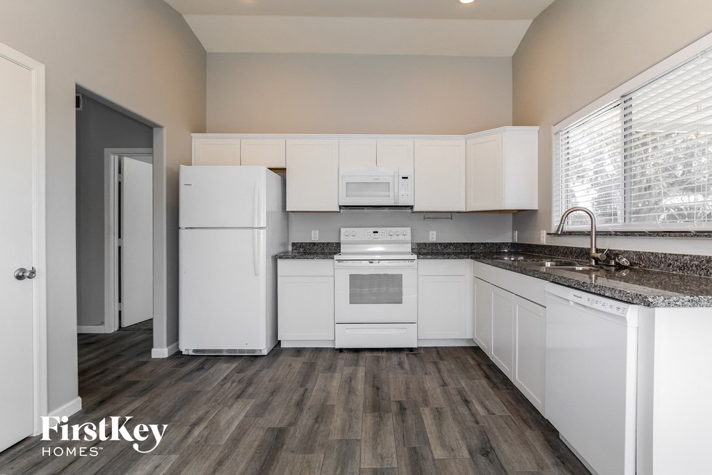 a white kitchen with white appliances and white cabinets