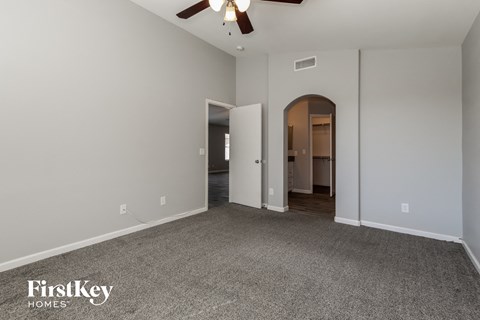 a living room with carpet and a ceiling fan