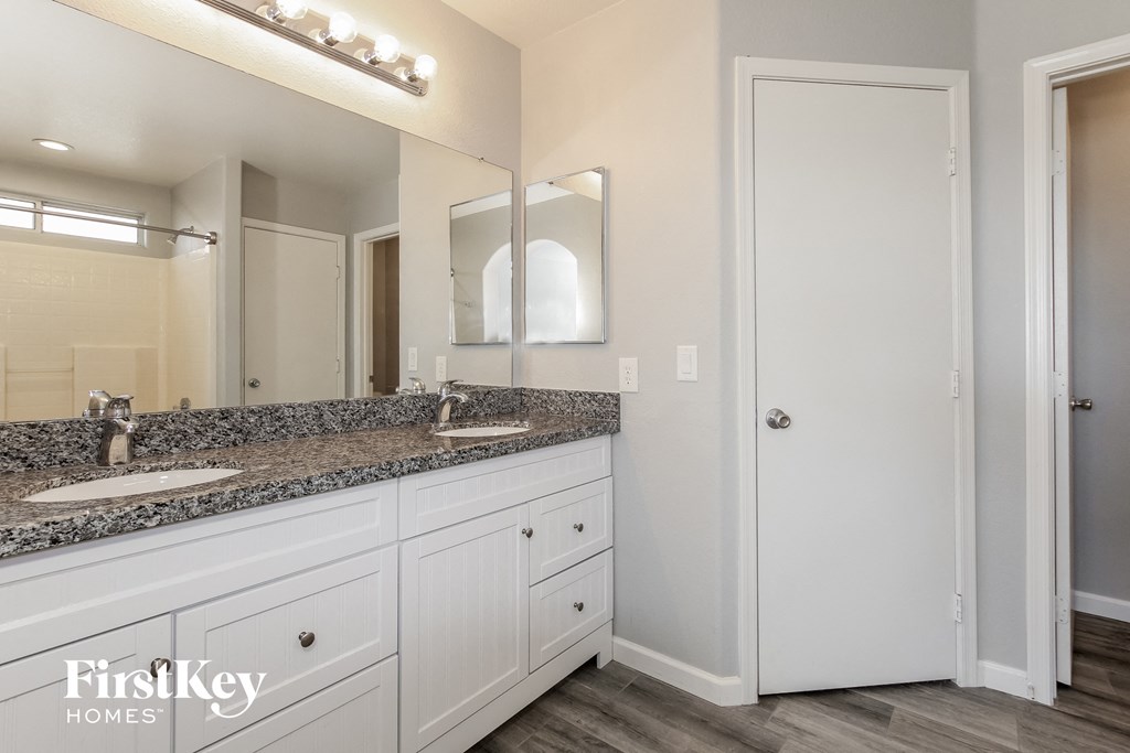 the master bathroom has dual sinks and a large mirror