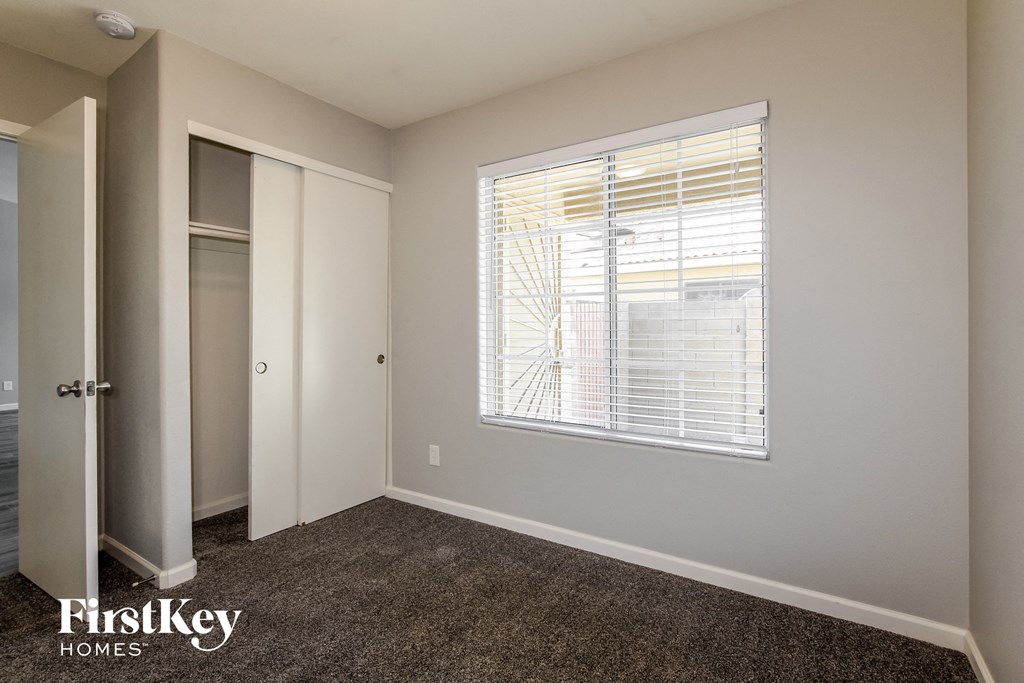 a bedroom with a large window and a closet