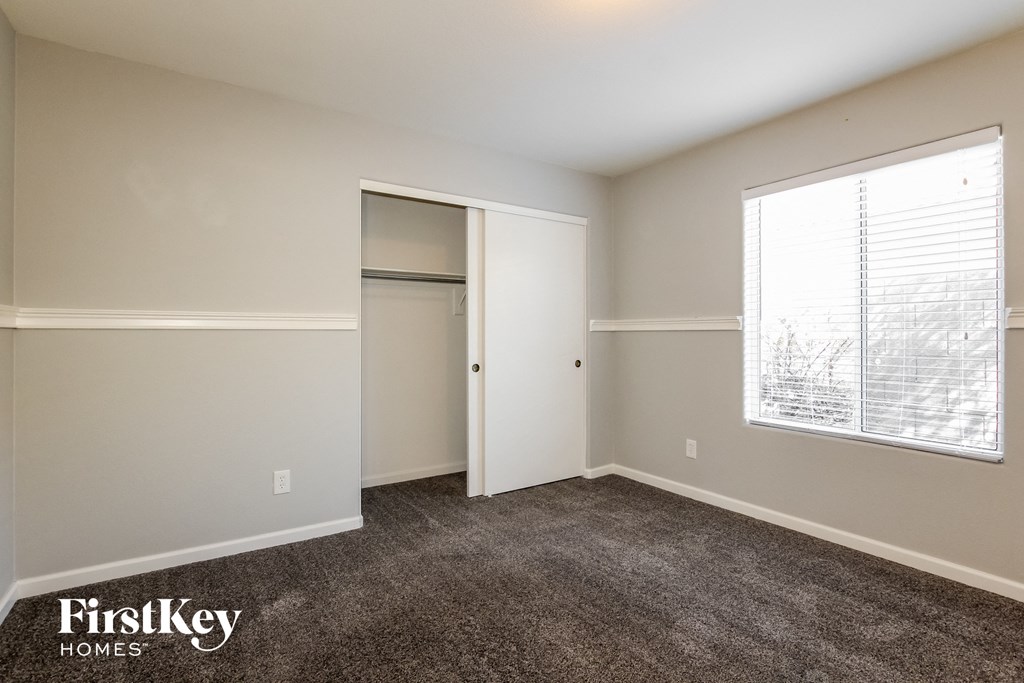 a bedroom with a closet and a large window