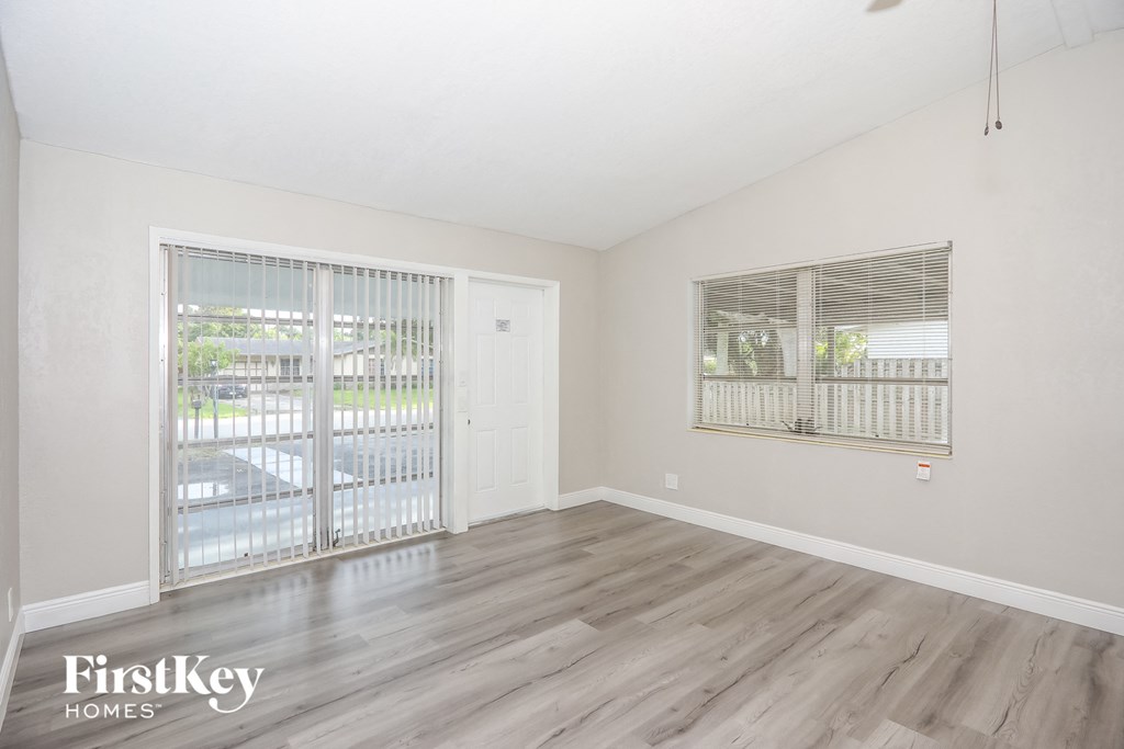 A room with wooden flooring and a sliding glass door.