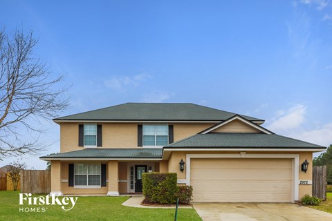 a yellow house with a garage and a blue sky