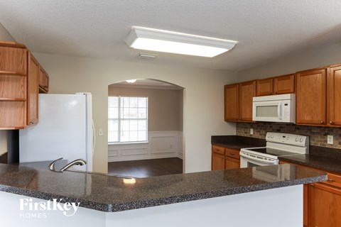 an empty kitchen with a granite counter top