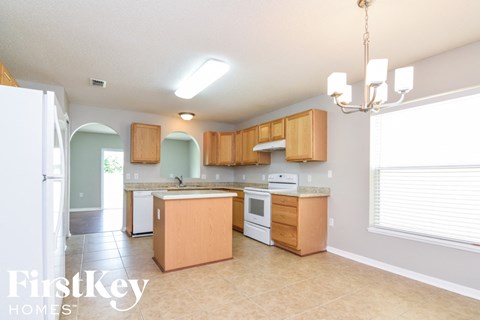 A kitchen with wooden cabinets and a white refrigerator.