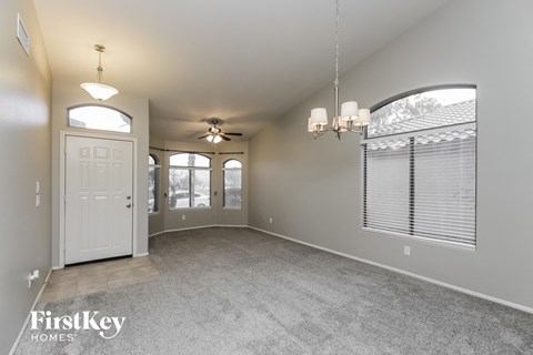 an empty living room with a white door and windows