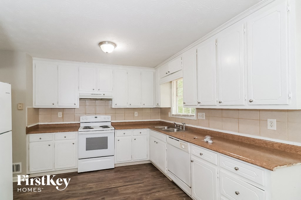 a white kitchen with white appliances and white cabinets