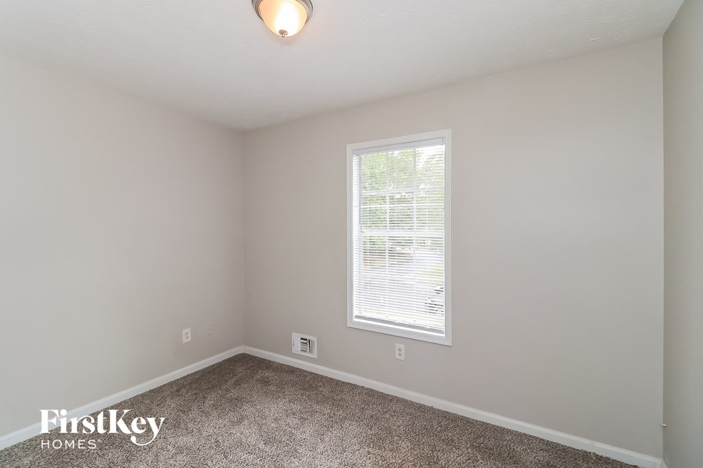 a bedroom with a carpeted floor and a window