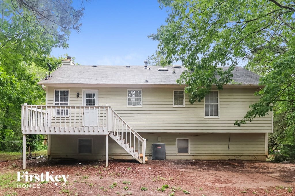 a white house with a white deck and trees