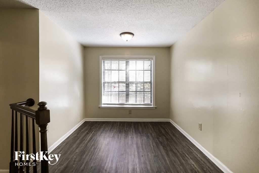 an empty room with wood floors and a window