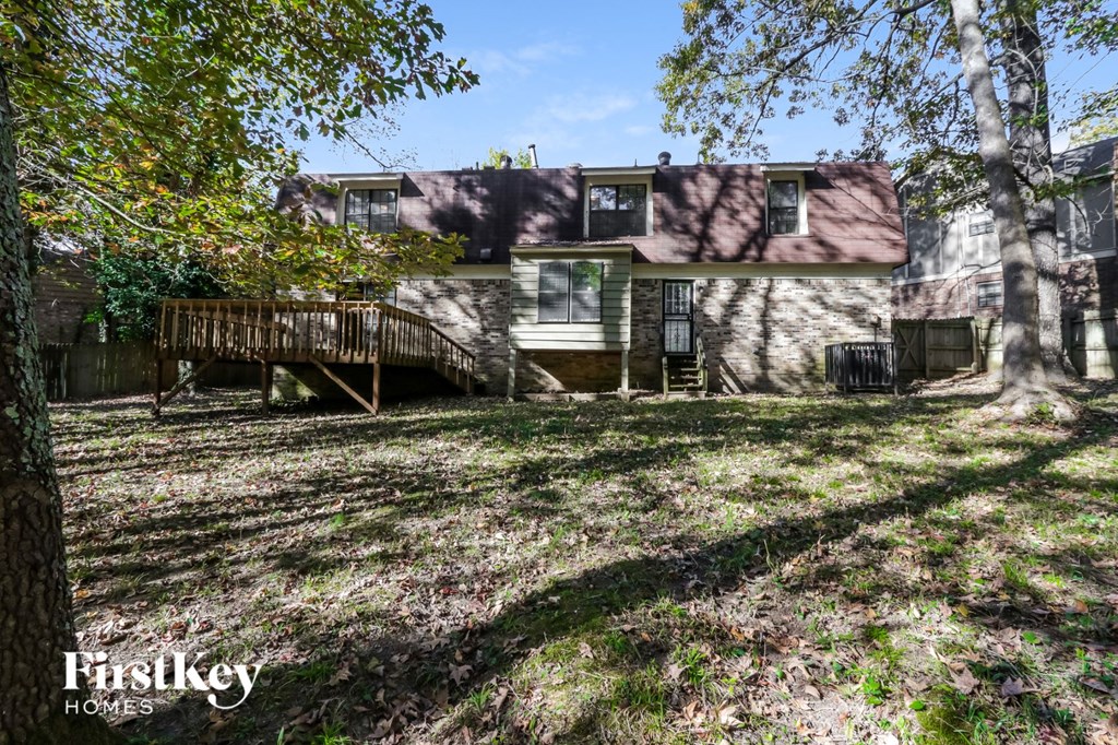 a house with a deck and a yard with trees