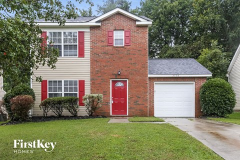 a red brick house with a red door and a white garage door