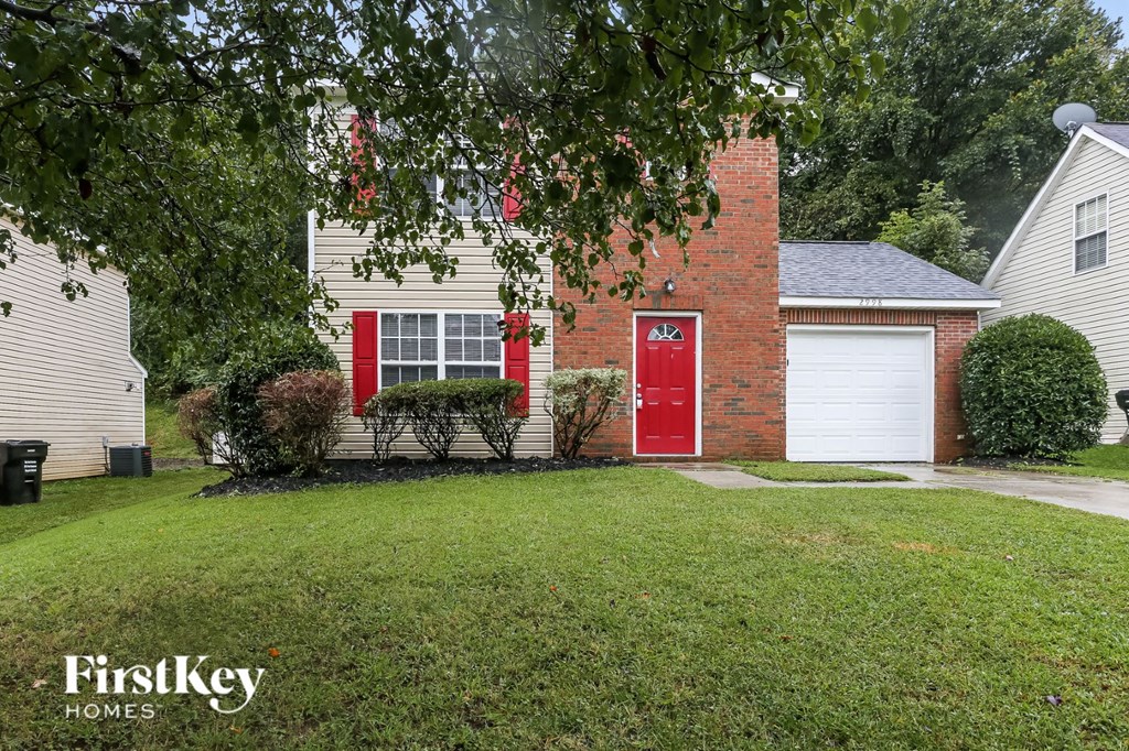 a red house with a red door and a lawn