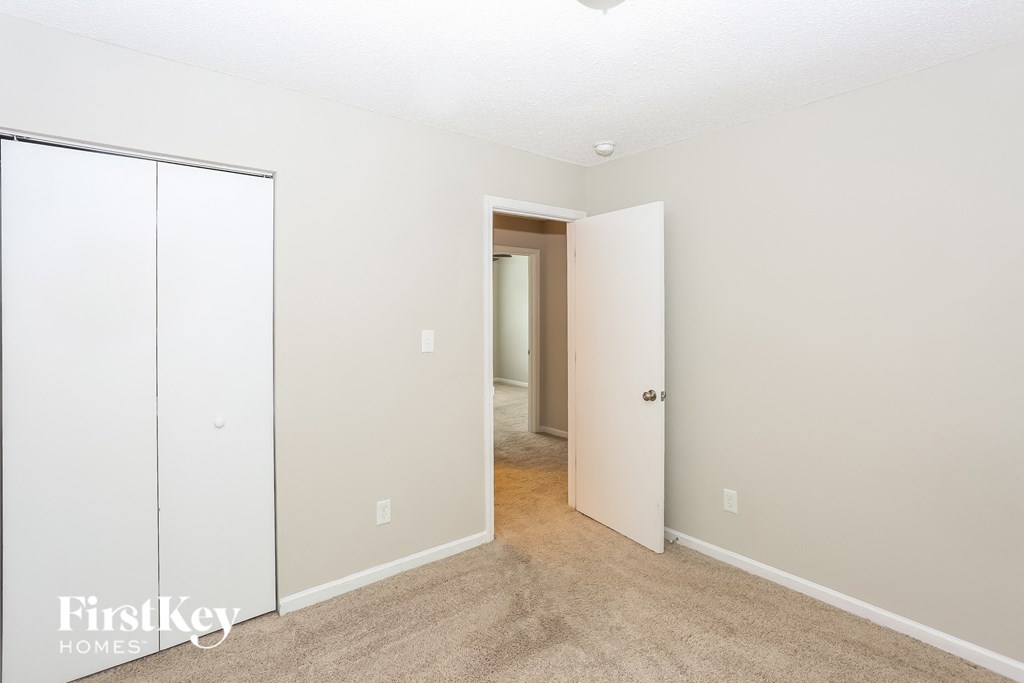 a bedroom with a closet and a door to a hallway