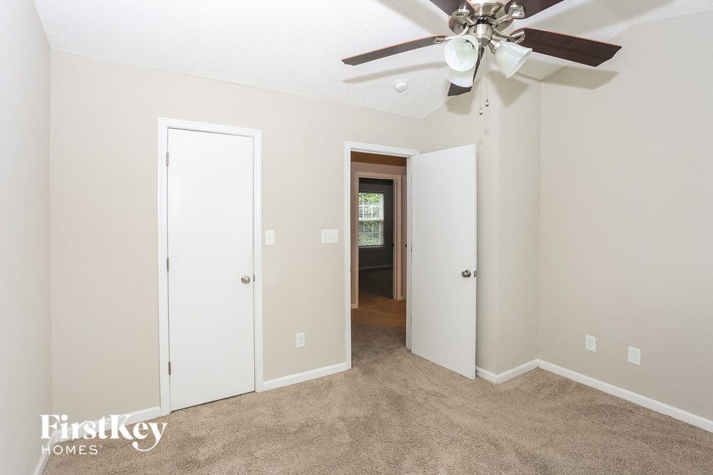 a living room with carpet and a ceiling fan