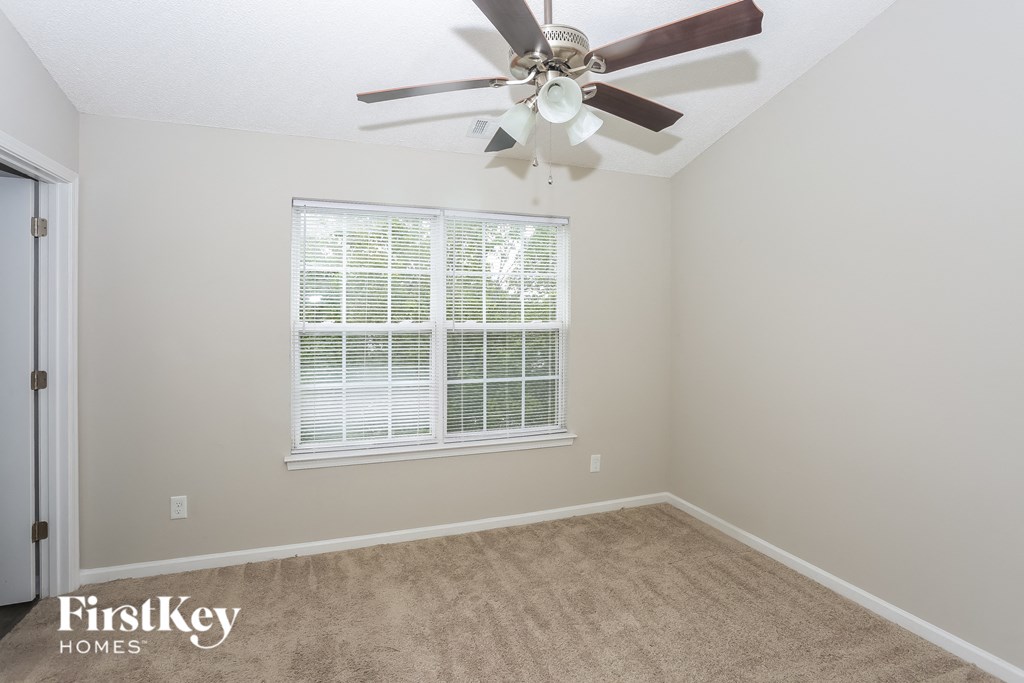 a bedroom with a ceiling fan and a window